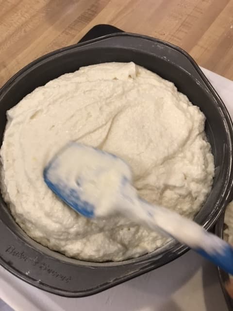Divide the batter evenly between the prepared cake pans and smooth the tops with a rubber spatula. They're ready for a 350F preheated oven.