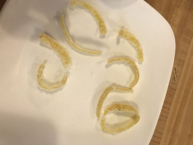 Remove the excess sugar by shaking it gently, and lay the candied lemon peel out to dry. It should only take a couple hours for them to firm up and be ready.