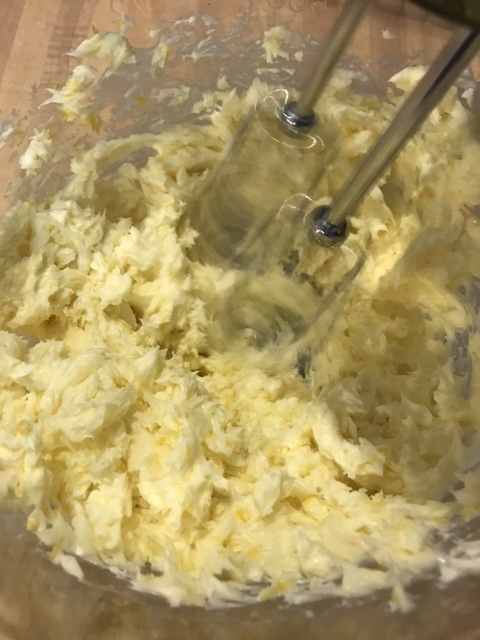 The butter and lemon zest are beaten with a mixer until light and fluffy. This gives the finished frosting it's beautiful consistency, so a little patience here works wonders. Keep beating the butter and lemon zest until it lightens in color.