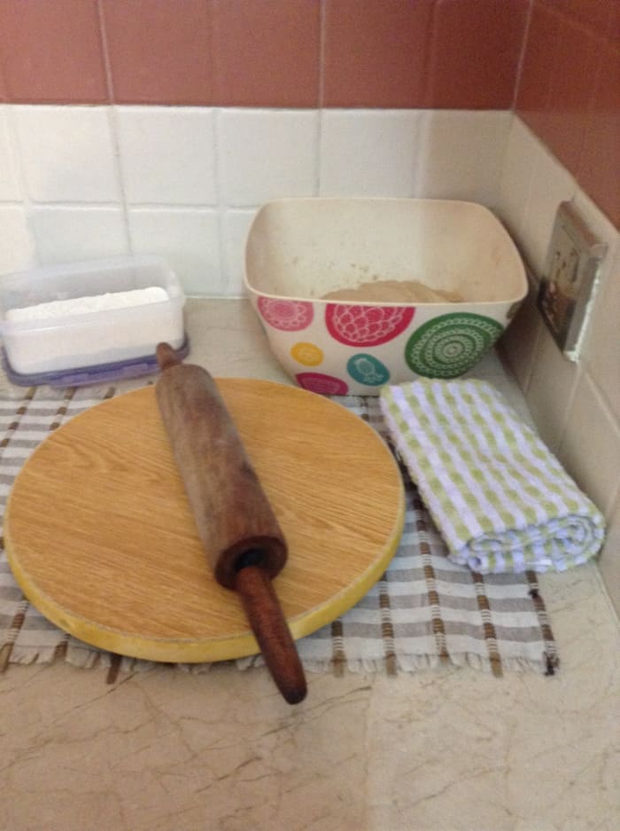 Now take a rolling pin, a wooden board, some dry flour and a kitchen towel (for pressing the Chapati on hot pan).