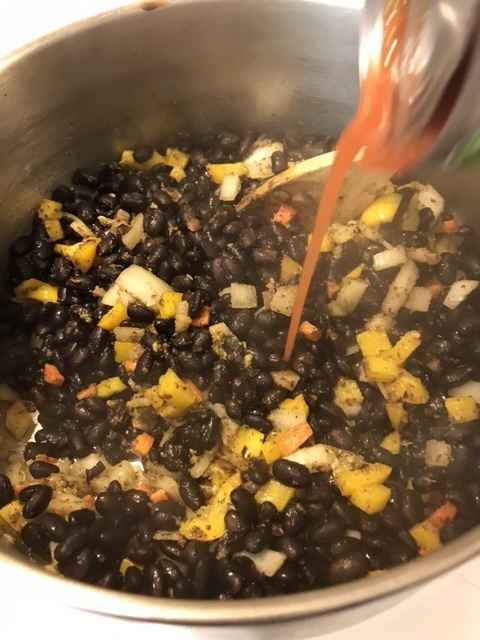 Stir in the drained and rinsed black beans, the tomatoes with their juices and the chicken broth. Stir to combine and bring just to a simmer.