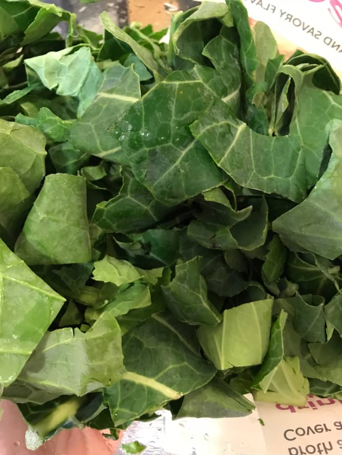 Wash and trim two pounds of collard greens, about two large bunches. Remove the stems if they are very large, they can be really tough and fibrous. The smaller stems will break down and soften, so leave those.