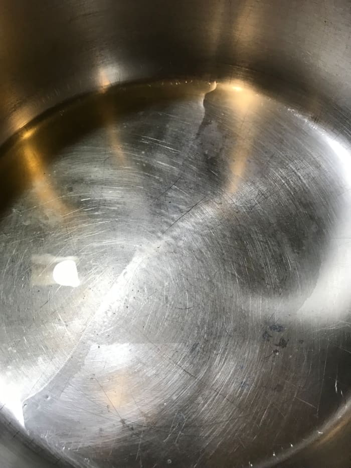 It only takes a little olive oil for this dish - I use just barely enough to cover the bottom of the pot. Choose a large saucepan or soup pot - the greens have a huge volume at first, so you'll need the room.