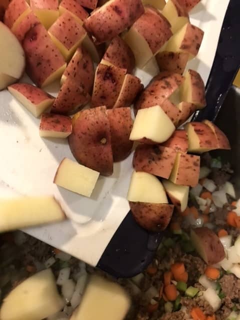 Stir in the potatoes once the onions have become fragrant and stir well. You're ready to add the broth!