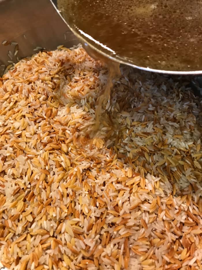 Add the hot broth to the rice and orzo. Stir it and then cover. Set a timer for 15 minutes - this is plenty of time to cook the rice and to allow the liquid to fully absorb.