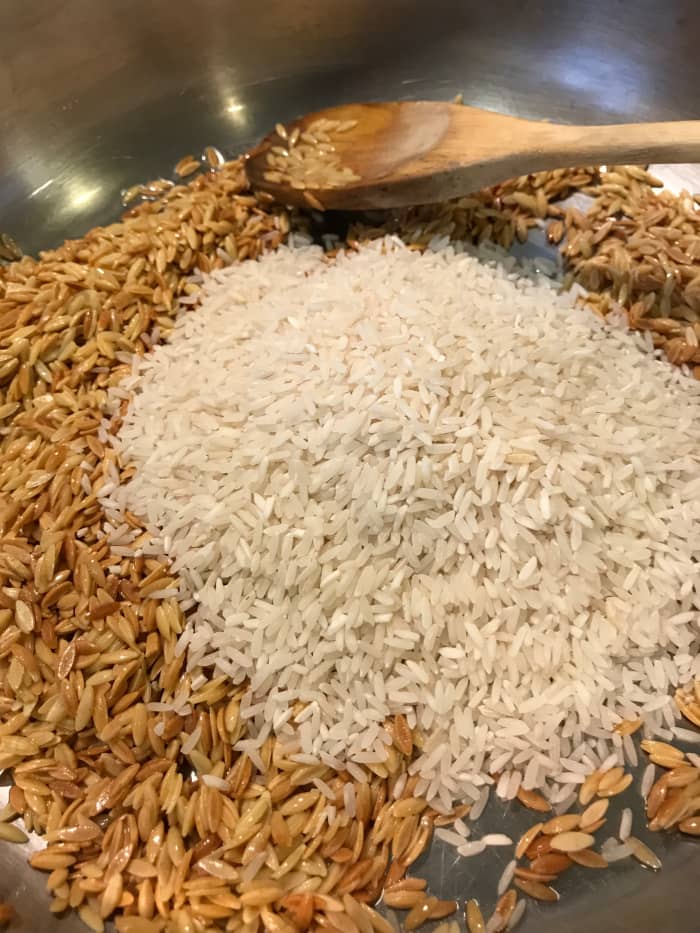 Once the orzo is nice and golden, add the rice to the same skillet. Stir it well - try to get every last grain of rice coated with the oil from cooking the orzo. This helps keep the texture beautifully fluffy.