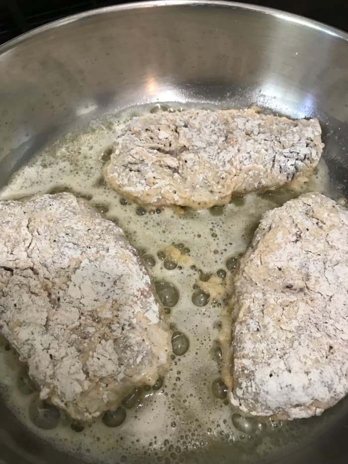 Create the crust on the steaks by dipping them in flour, then buttermilk, then back in the flour. Brown them on both sides, about five minutes. Don't crowd the pan - just a few at a time allows browning. Too many and they'll steam and stay soggy.
