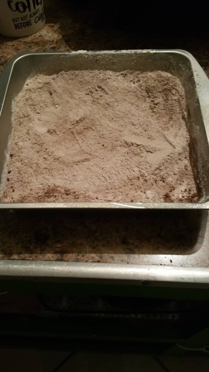 In an 8-inch greased baking dish, combine and mix together the flour, baking cocoa, sugar, baking soda, and salt.