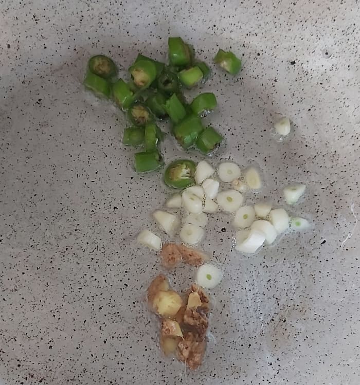 Heat 1-2 tablespoons of olive oil (or you can use any cooking oil) in a pan, add chopped ginger-garlic and green chilies.
