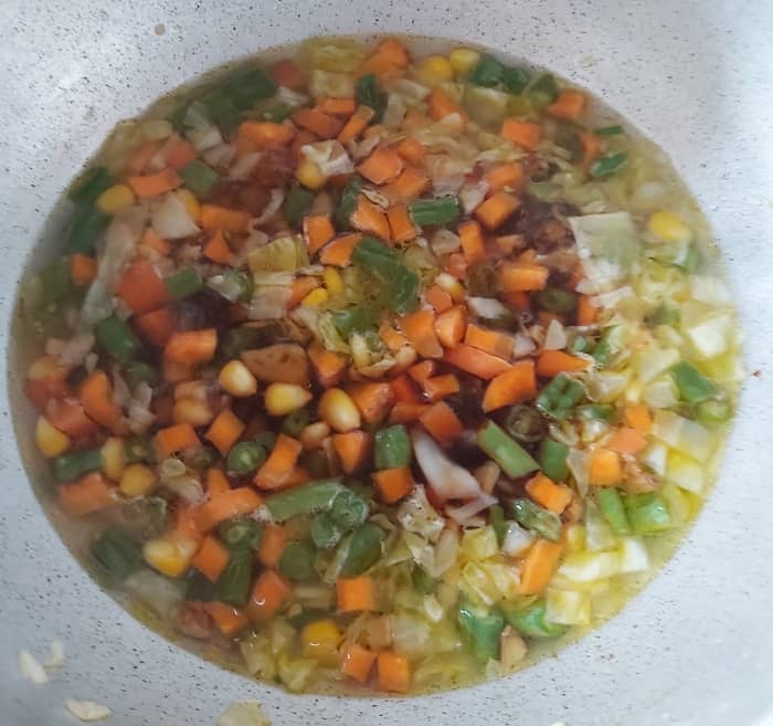 When vegetables are half cooked, add 1-2 tablespoons of soy sauce and 1 tablespoon of red chili sauce (or you can use green chili sauce).