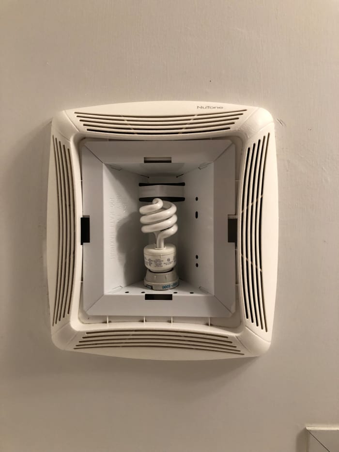 Pay attention to the manufacturer's assembly instructions. Tightening a nut on this unit's metal light bulb fixture forces the plastic fan louver tight against the ceiling and the light cover snaps into the rectangular slots next to the louver.