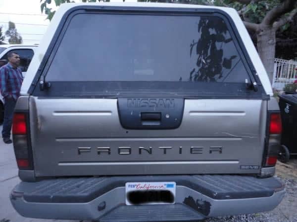 This is the back of an '01 Frontier; notice how it has changed from the earlier truck in the last photo. This owner has managed to fit an older top on it, and you can see the door kind of works, good enough I guess.