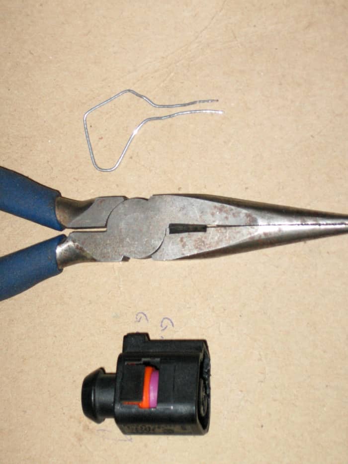 Needlenose pliers, replacement part, and paperclip for replacing broken wire-harness clips and connectors.