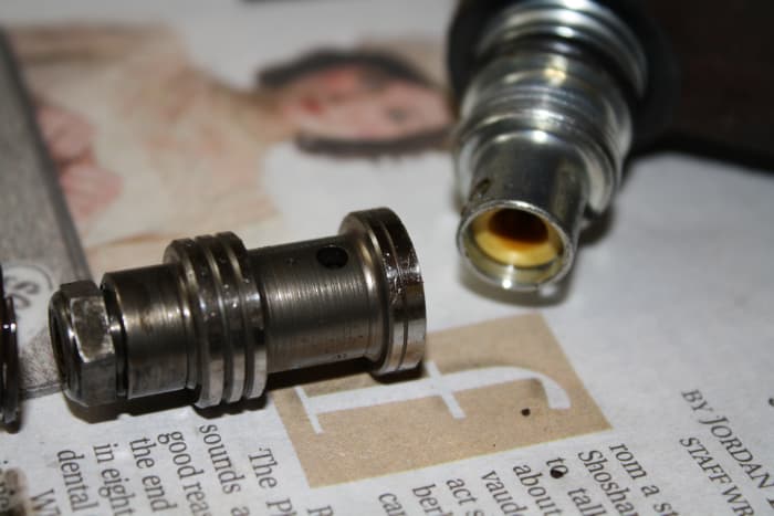 The pressure relief valve piston sits beneath the pressure fitting and is spring loaded. Don't let it pop out on the floor.