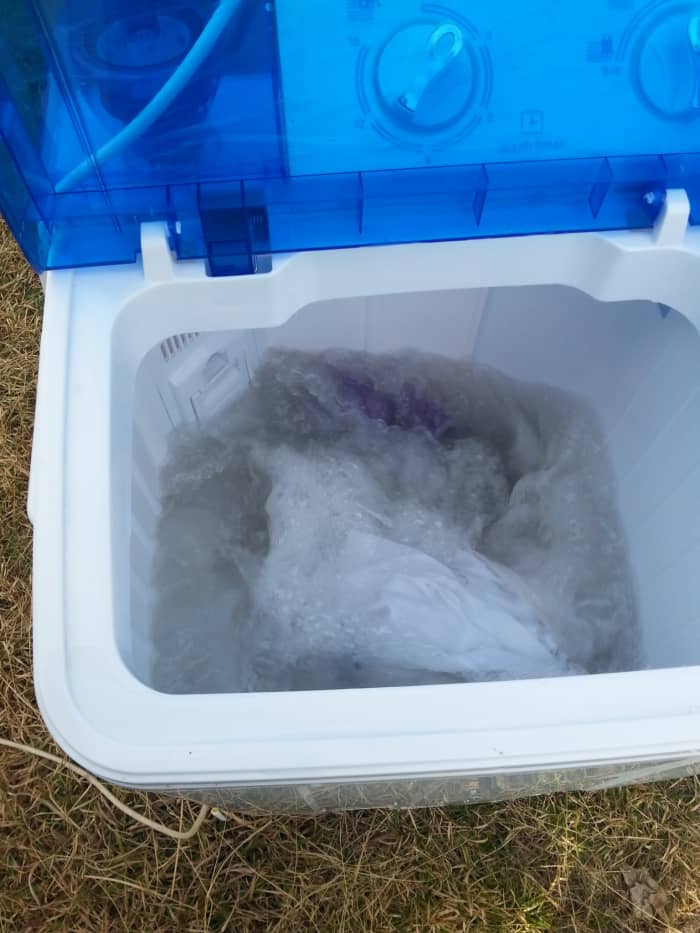 Here's my RV washing machine in action out on the grass. I ran an extension power cord to it, filled it with a garden hose, and watered the dry lawn when draining it!