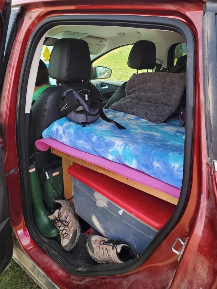 Customize your car bed to fit in your car, and make it high enough to provide extra storage underneath. We use storage bins to keep our belongings organized.