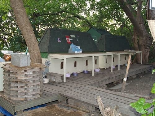 Multi cat house: This wouldn't be hard to make. It's a basic box construction, subdivided inside with holes cut out for doors and a peaked roof set in place.