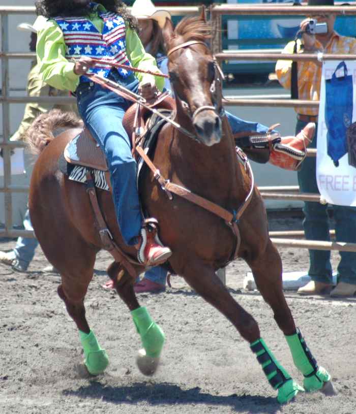 In barrel racing horses and riders must learn to lean in to tight turns.