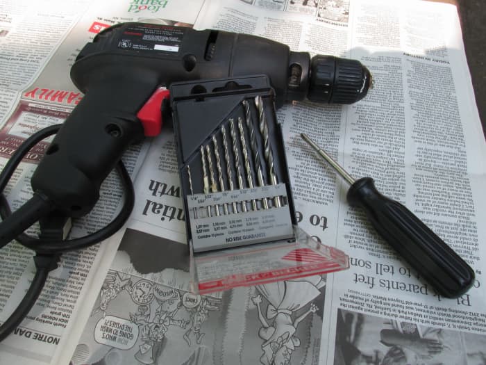 Electric drill, set of drill bits and screwdriver for attaching the scroll plant hanger.