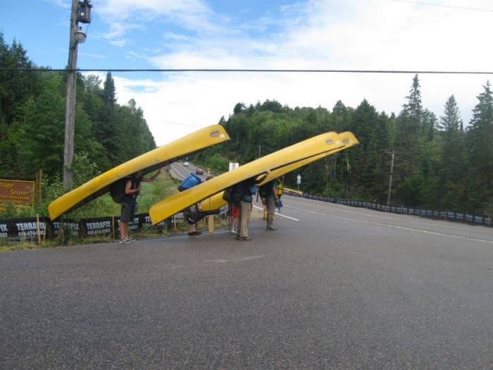 A group of canoeists heading out for a portage in Algonquin Provincial Park. Unless your dog is extremely well trained & used to being in the woods, it isn't advisable to take your dog with you for a long portage trip.