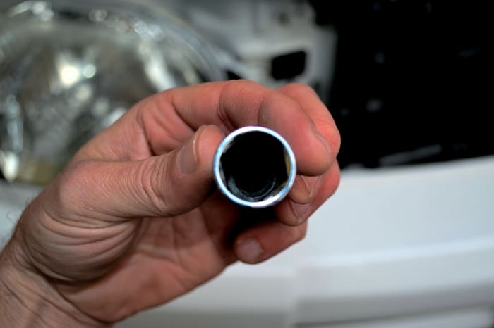 Head on look at a spark plug socket. Notice the rubber insert inside that grips the plug to extract it and lower it back in without the plug falling into the plug tube.