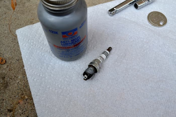 Prepping the plug to go back in, notice the silver anti seize lubricant applied to the threads. Do not use too much, a little goes a long way. Apply to the threads ONLY ... make sure not to get any on the electrode.