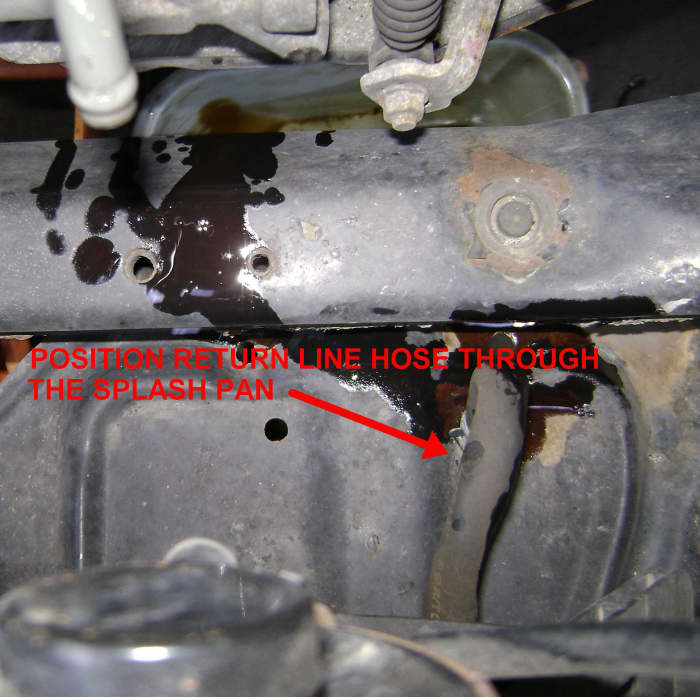 Run the ATF return line hose through the splash pan hole