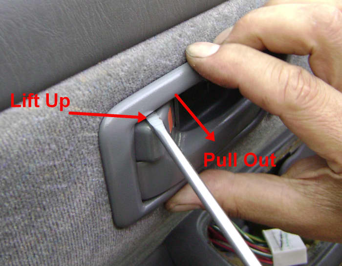 e. Position a thin screwdriver between the handle bezel and the inside handle (see photo) and release the upper connection by pulling out.