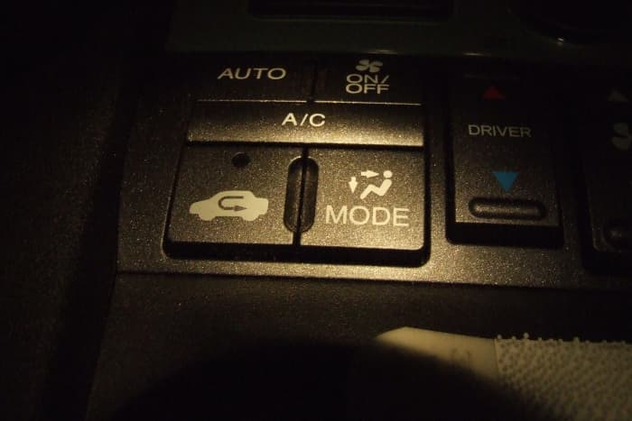 Recirculation button (at left) next to the fresh air button (at right) (2011 Honda Pilot). The recirculation button should be on when using air conditioning, but should not be on otherwise; it will fog up your windows.