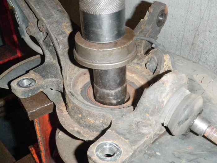 Press the center of the wheel bearing out first to access the snap ring.