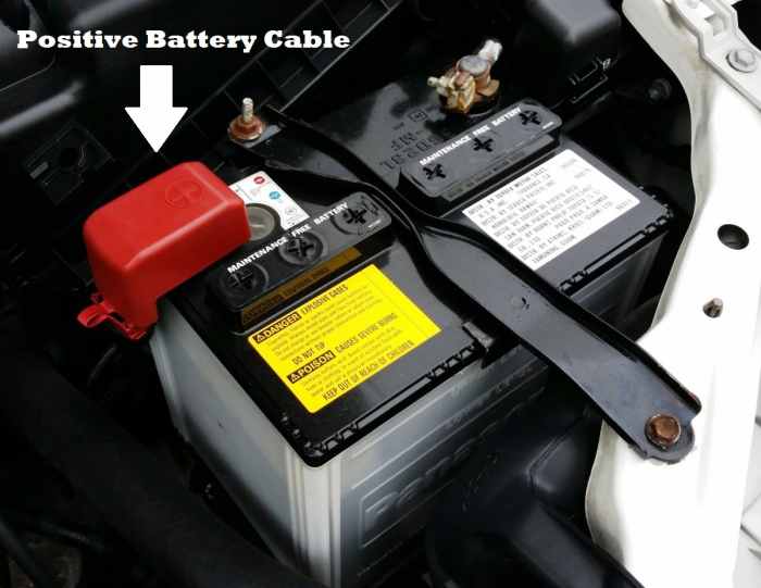 Remove the red rubber boot (if present), then loosen the battery cable clamp with a wrench. This will allow you to remove the positive battery cable.