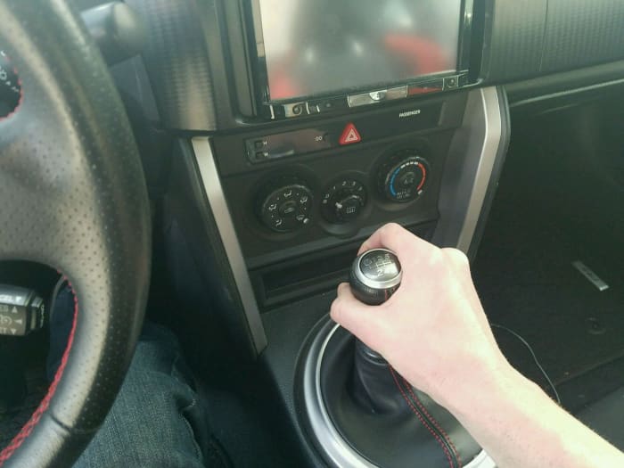 To shift from first to second, press in on the clutch and pull the gear shift down (towards you). To shift up to third gear, press in on the clutch and move the gear shift up and to the right.