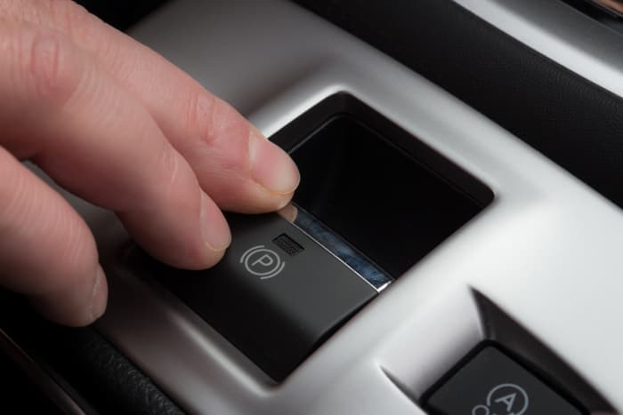 Some cars have a push-button emergency, or parking, brake control (as above). Many others have a lever with release button at the end. 