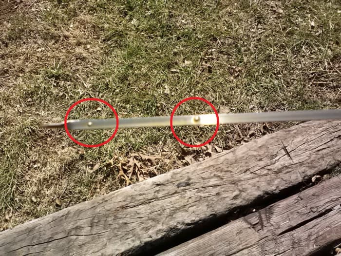 Closeup of the engine oil dipstick, circled dot in left of photo indicates lower mark, circled dot in right of photo indicated the upper or "FULL" mark
