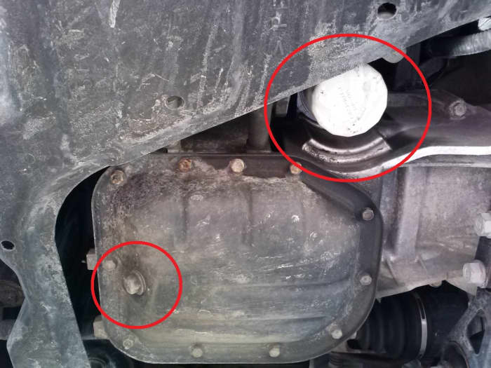 In the lower left, we see the oil drain bolt which requires a 14 mm socket to remove and in the upper right of this photo, we see the oil filter which can generally be removed by hand without any additional tools.