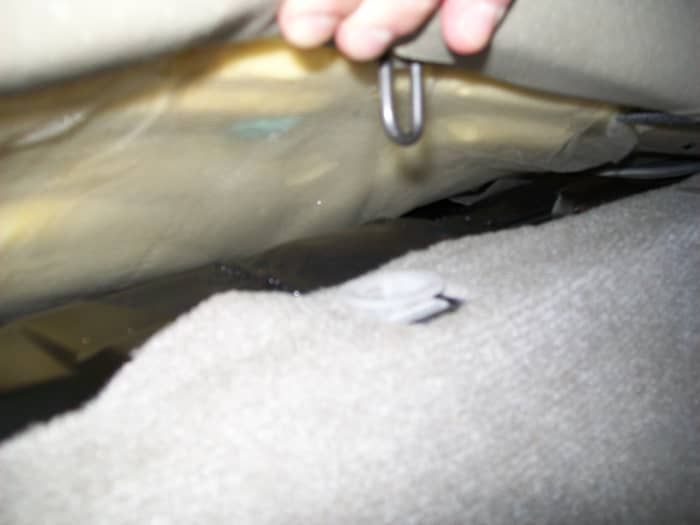 The seat cushion is held in place by two of these loops, one on each side, that pull out easily.