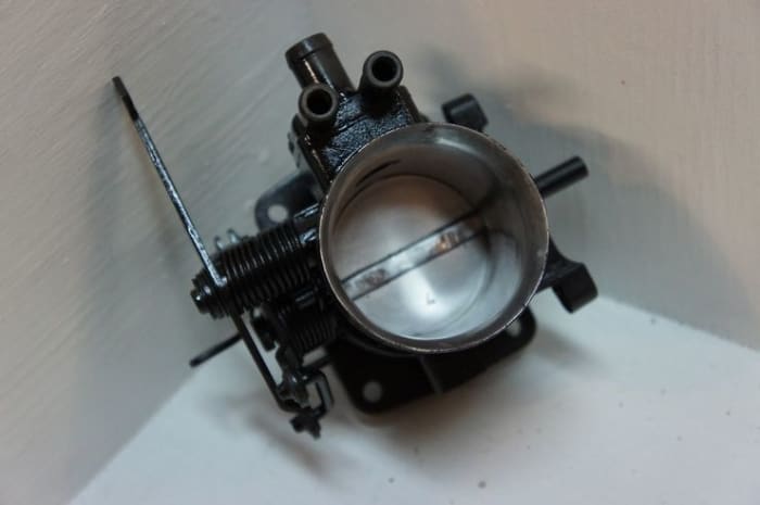 On throttle body injection (TBI) systems, the fuel injector is located on above the throttle plates when assembled.