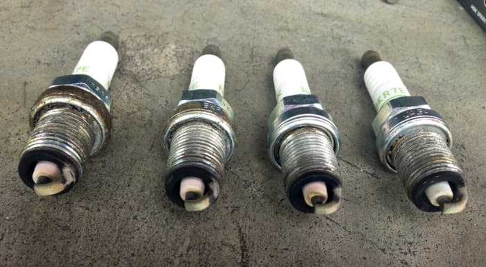 These plugs are looking A-OK, luckily. A pretty-clean insulator and tan-to-gray deposits on the electrodes. NGK says a bit of grime by the "hex" above the threads is normal and caused by static charging when firing. Dried anti-seize on plug 4.