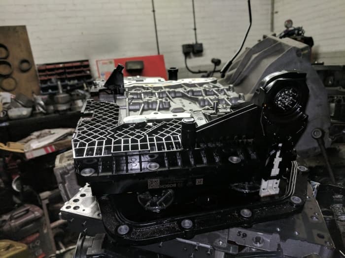 The mechatronic unit from a ZF6HP26 automatic transmission, together with the valve body which it controls.