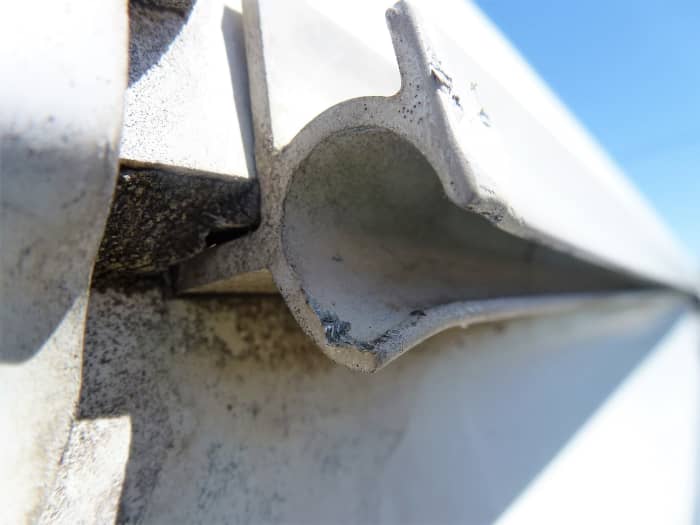 The lower corner of the track was bent down slightly to prevent tearing the new awning. The upper corner could not be bent with any reasonable force because of the way it was constructed.