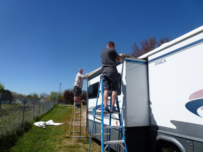 Unrolling the awning. The spring is fairly strong and two people will make it much easier.