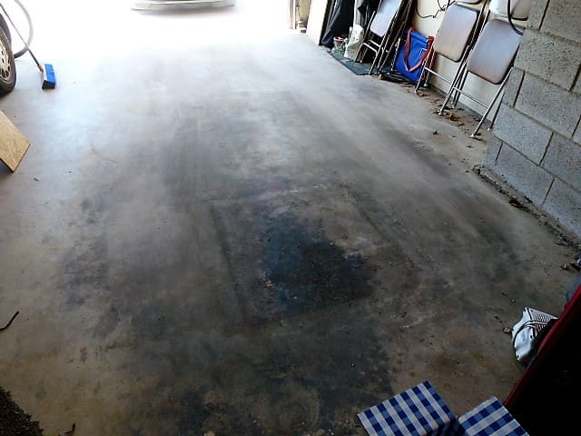 This garage floor has a large oil spot that was covered with scrap plywood before laying the awning down. Don't set your new awning in a puddle of oil!