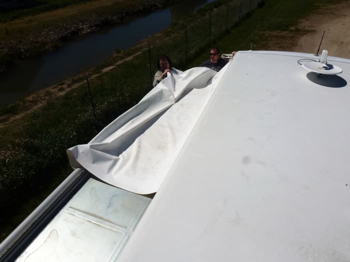 The awning is about half way installed. Two helpers aided feeding the material into the tracks while a third person on the roof pulled it in.