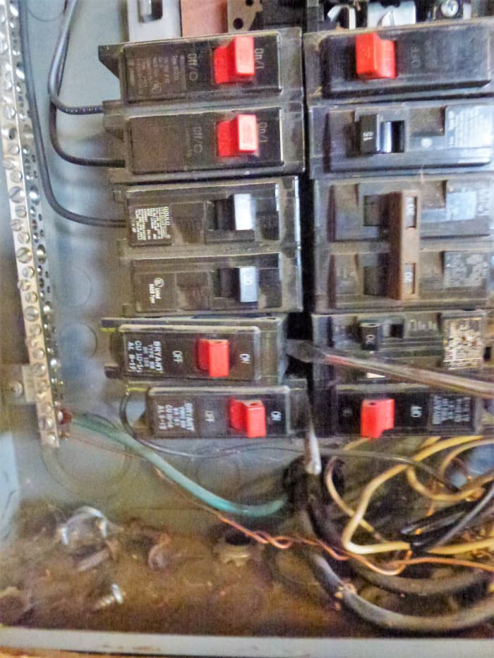 Removing a breaker. A screwdriver is being used to carefully pry up the side in the center of the panel.
