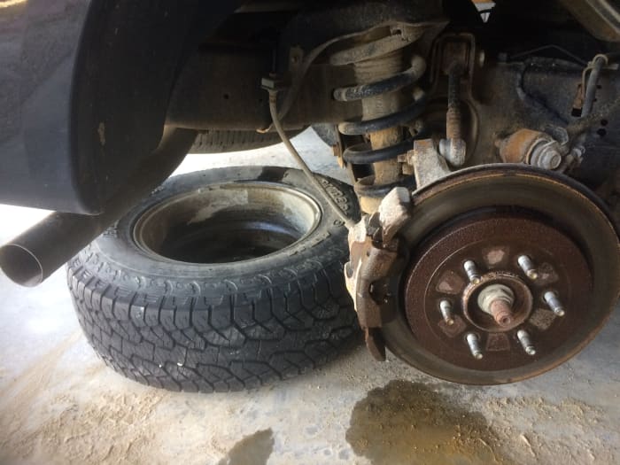 A good safety tip is to use the old tire as a spacer—just in case your jack fails and the car drops down.