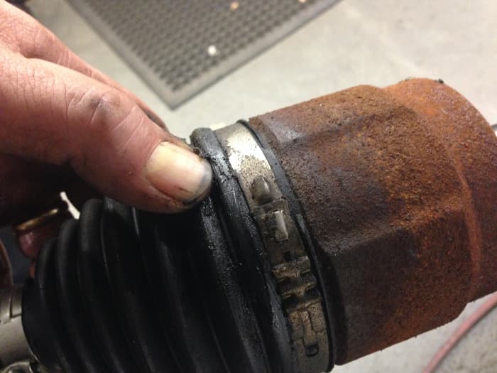 Here you see an inner CV joint boot split near the cup, causing grease to leak from the joint.