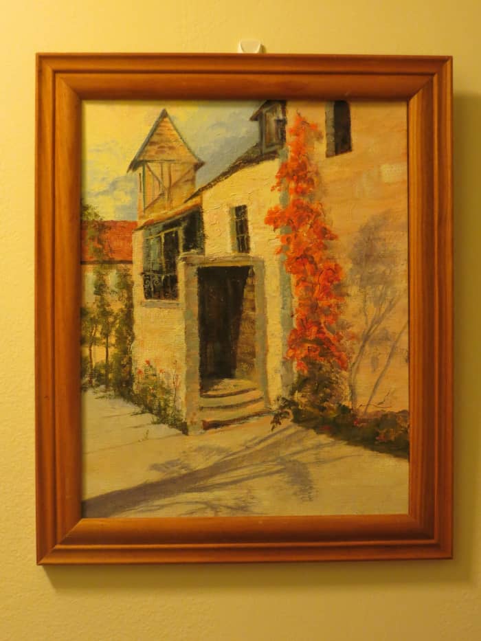 When my grandmother framed her painting, she attached a wire hanger to the back. The wire now rests comfortably on the Command hook behind it.