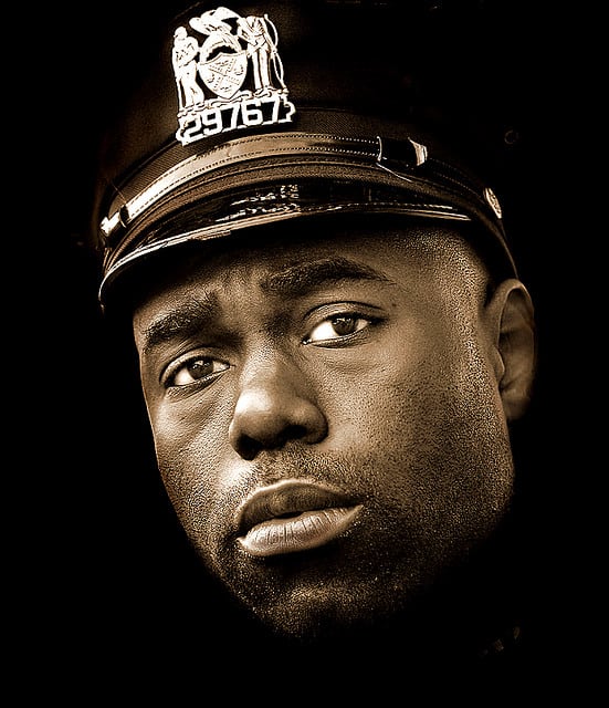 A cop expresses the cumulative effects of his job in his eyes.