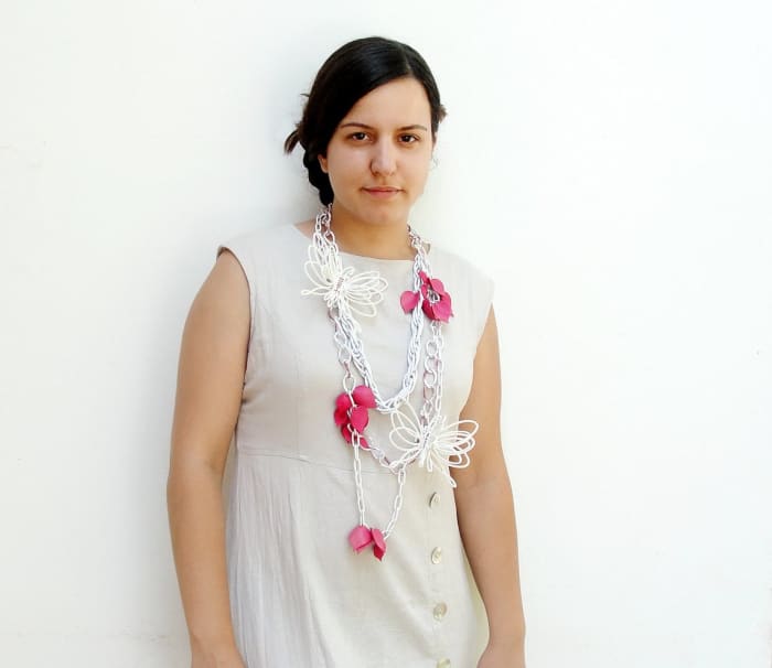 The model is wearing a necklace, that would otherwise look different if laying on a table. Staging in this case shows the potential buyer the size, style, and fit!