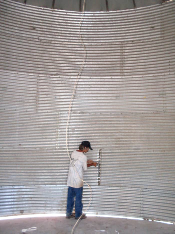 Hubby hard at work on stiffeners, which are bars that help the bin hold up against the thousands of pounds of grain without buckling.
